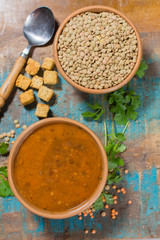 Homemade brown lentils soup in old clay bowl