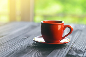 A cup of red espresso on a wooden table in the cozy interior of a cafe