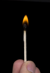 Closeup of burning match, black background