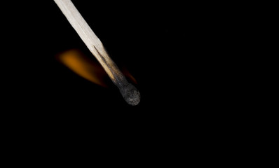 Closeup of burning match, black background