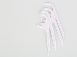 Close up of dental floss toothpicks on the white background.