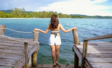 Woman standing on the wooden bridge over the sea. Travel and Vacation. Freedom Concept. Kood island at Trad province, Thailand