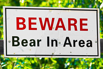 a white beware bear in area sign
