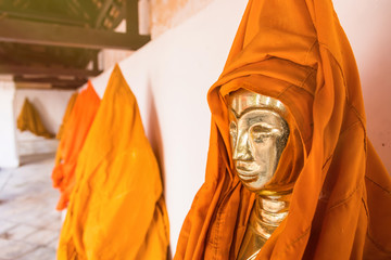 Ratchaburi, Thailand - July, 23, 2017 : The statue of golden Buddha is covered with orange robes in...