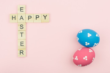 Text wooden blocks spelling the word happy easter on pink background