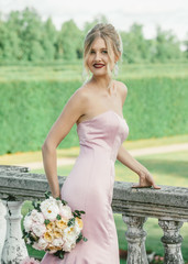 Fototapeta na wymiar Bridal Fashion. Portrait of young beautiful modern bride with stylish make-up and hairdo holding peony bouquet in her hands.
