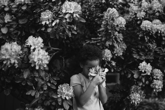 Young girl in garden, smelling flowers, black and white