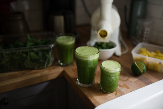 Three glasses of freshly made juice on kitchen work surface