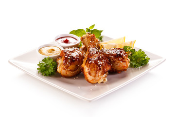 Roast chicken drumsticks on white background