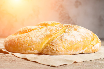delicious baked good on a light textile background in rays of the sun, capital bun