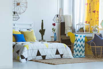 Trendy bedroom with yellow accessories
