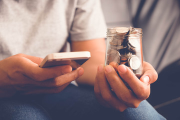 save money for investment concept Hand holding money in jar with filter effect retro vintage style