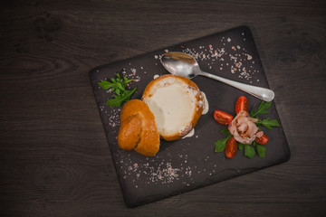 Fresh pea soup in a Bread Bowl, on a wooden board with salt and papper