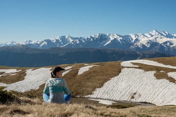 Fototapeta premium Woman traveler is relaxing admiring mountain range