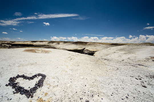 heart made of pebbles in a rock desert in the USA with a blue sky behind