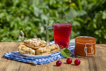 Jam shortbread cookies and red compote with cherries, strawberries, gooseberries, raspberries and apricot jam