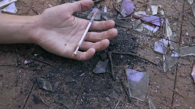 Man's hand Falls to floor just pricked heroin or meth drugs.