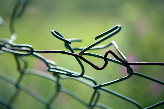 broken mesh fence as a symbol of defencelessness