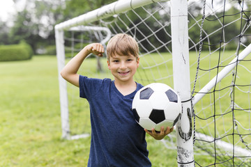 Young Boy with football on a field having fun