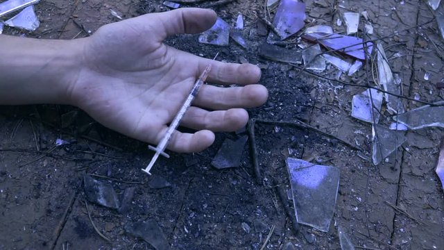 Man's hand Falls to floor just pricked heroin or meth drugs.