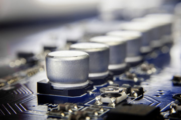 Obraz na płótnie Canvas Close up macro of aluminum electrolytic capacitors installed on the motherboard and electronic component with selective focus. Electronics part concept.