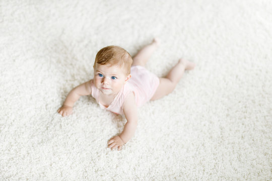 Little Funny Baby Girl Lifting Body And Learning To Crawl.