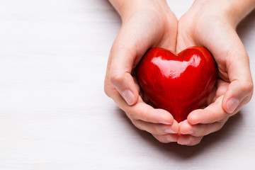 Fototapeta premium Red wood heart in child hands