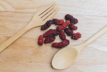 Mulberry spoon and fork on a wood plant, mulberry have Red and black color and  berry fruit good health