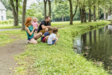 Families with children close to a waterscape with duck on it