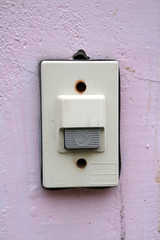 door bell ring on the pink wall. doorbell is a bell in a building that can be rung by visitors outside to signal their arrival.