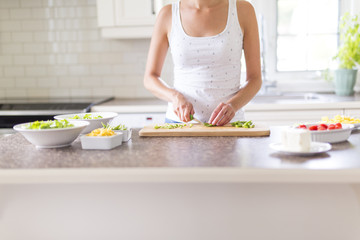 Obraz na płótnie Canvas Gorgeous woman doing a salad in her kitchen
