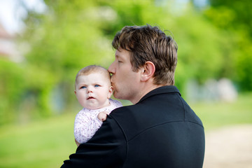 Happy proud young father with newborn baby daughter, family portrait togehter