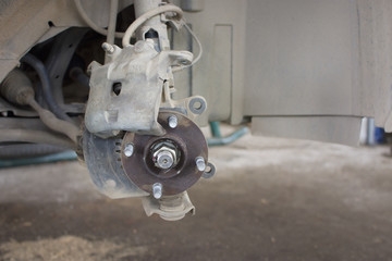 Repairing a car suspension in a auto mechanic shop.