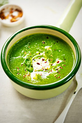 Broccoli spinach pea cream soup with cream and chilli flakes 