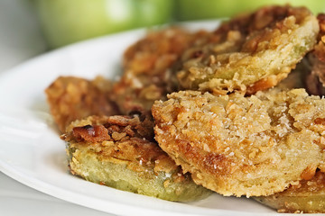 Plate of fresh fried green tomatoes. Tomatoes have been coated in cracker crumbs before frying. Extreme shallow depth of field with selective focus.