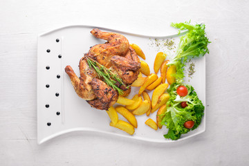 Chicken Grill, Potatoes and Fresh Vegetables. On a wooden background. Top view. Free space for your text.