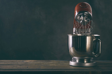 Kitchen mixer standing on wooden countertop