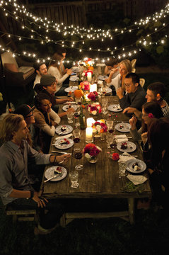 Group of friends having a dinner at backyard party