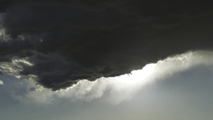 edge of a cumulus cloud with wispy edge backlit by the afternoon sun
