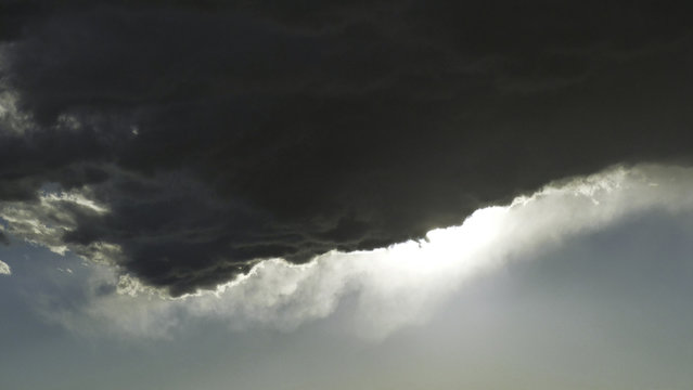 edge of a cumulus cloud with wispy edge backlit by the afternoon sun