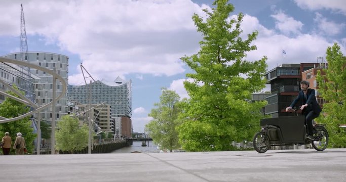 Handsome man transporting things through the city with his cargo bike