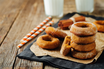Baked pumpkin donuts with glasses of milk