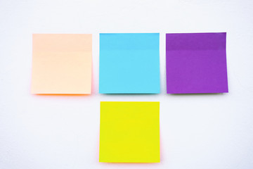 Four 4 colorful sticky paper on a wall.
