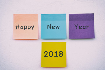 Happy New Year 2018 on colorful sticky paper on a wall, pastel colors.