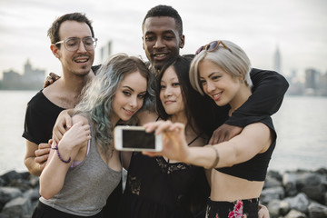 Multi ethnic group of friends taking a selfie outdoors
