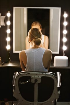 Professional actress in front of backstage mirror