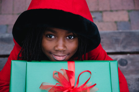 African American in red coat girl holding Christmas gifts