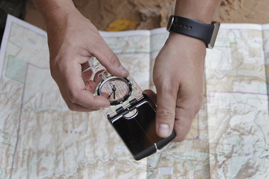 Man holding compass over a map