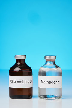 (English label / in portrait format) An ampoule of methadone and a chemotherapy stand on white surface against a blue background in the lower half of the image