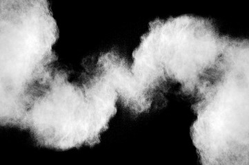 Freeze motion of white dust explosion on black background. Stopping the movement of white powder on dark background. Explosive powder white on black background.